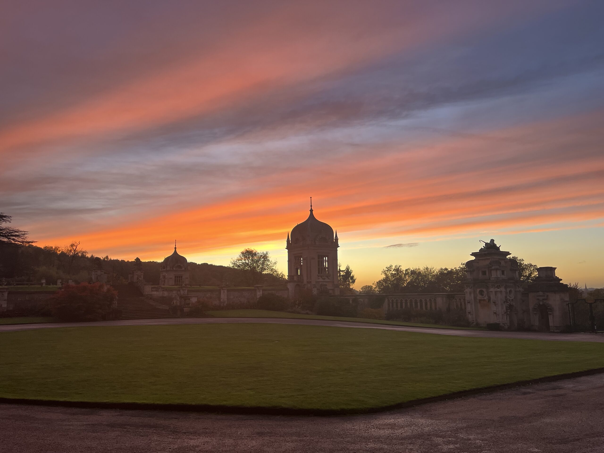 Landscape photo of the front driveway at Harlaxton Manor, facing the sunset.
